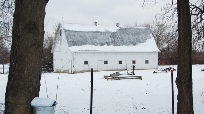 snow covered land and barn